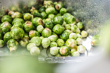 washing raw Brussels sprouts in kitchen sink