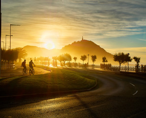 Obraz premium Słońce zachodzi za Monte Urgull w San Sebastian, Kraj Basków, Guipuzcoa. Hiszpania. Widok z Zurriola Avenue.