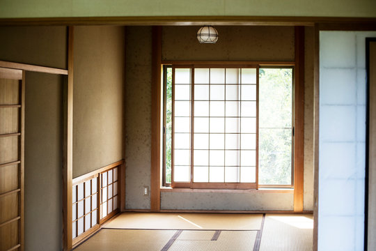 Interior of traditional Japanese house with tatami mats and opaque sliding doors.