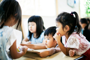 Group of children sitting at a table in a Japanese preschool.