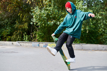 Full length portrait of young man doing skateboard stunts in extreme sports park, copy space © Seventyfour