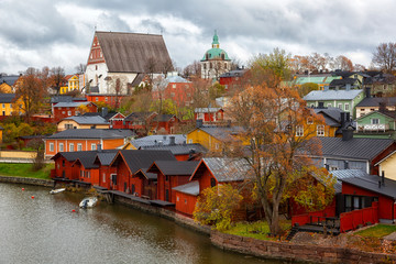 Red shore houses on the riverbank of Porvoo river. Old town of Porvoo in Finland in autumn.