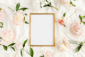 Fototapeta na wymiar Gold frame decorated of beautiful beige peonies. Flat lay, top view. Valentine's background. Floral frame. Peony texture.