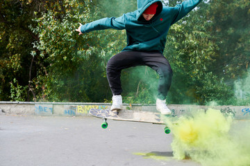 Full length portrait of modern teenager doing skateboard tricks in green smoke, copy space