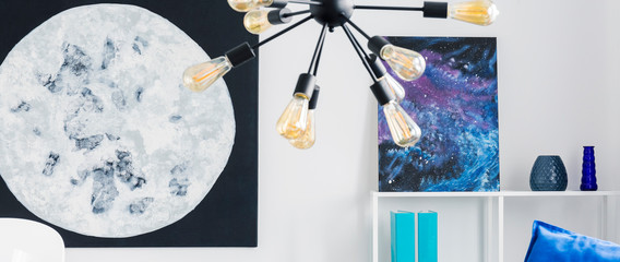 Panorama of lamp in white cosmos living room interior with moon and stars posters. Real photo
