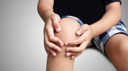 Asian kid with knee pain, isolated background