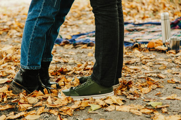  legs of guy and girl in autumn leaves