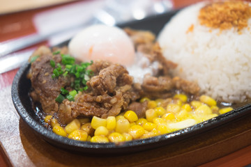 Pork teppanyaki with egg and corn in hot plate