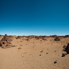 Fototapeta na wymiar desert landscape with volcanic rocks and blue sky -