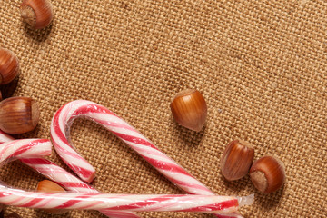 Christmas decoration background, fir tree, textile, beads, gifts, old paper, nuts and other stuff on sackcloth. Empty space for text, new year theme.