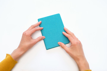 Beautiful female hands hold a blue notebook/diary