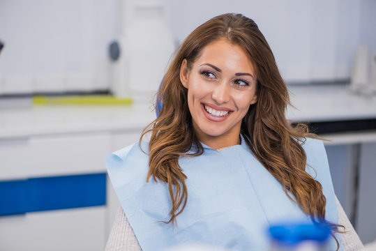 Young female patient talking with her dentist - Powered by Adobe
