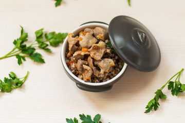 stewed chicken stomachs with vegetables and buckwheat in a bowl