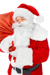 smiling santa claus carrying red christmas bag isolated on white
