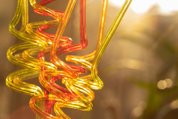 Color tubes for drinking juices. Curved in the form of a spiral. Blurred bright background...