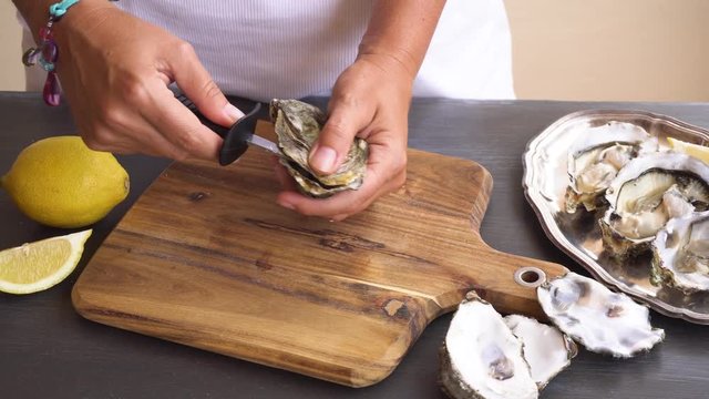 someones hands open fresh raw oyster shell
