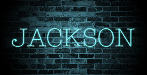 first name Jackson in blue neon on brick wall
