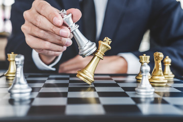 Businessman playing chess game reaching to plan strategy for success, thinking for planning...