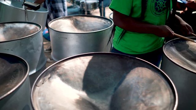 Closeup of mallets hitting steel drums.