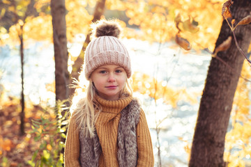 An Autumn portrait of cute blond child girl