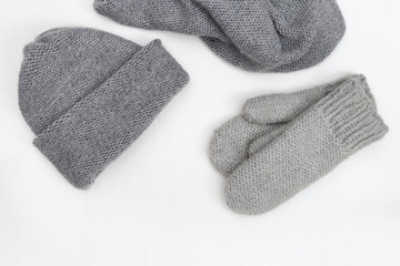 Warm winter women's clothing, knitted mittens, knitted hat, knitted scarf. Top view. Copy space.