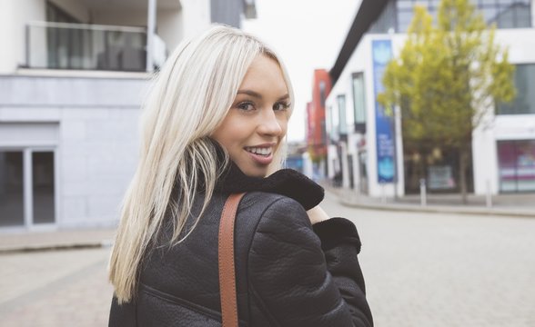 Blonde woman looking at camera in city