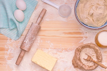 Baking background. Preparation of the dough. Accessories for preparation of the dough: sieve, rolling pin, board, spoon. Food, ingredients for making dough, eggs, butter, flour, sugar.