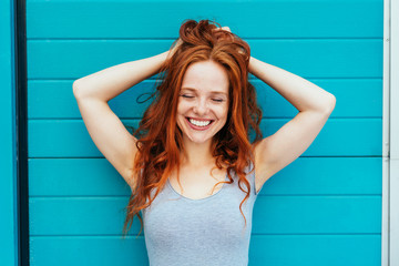 Smiling happy woman running hands through hair