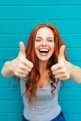 Excited vivacious young woman giving a thumbs up