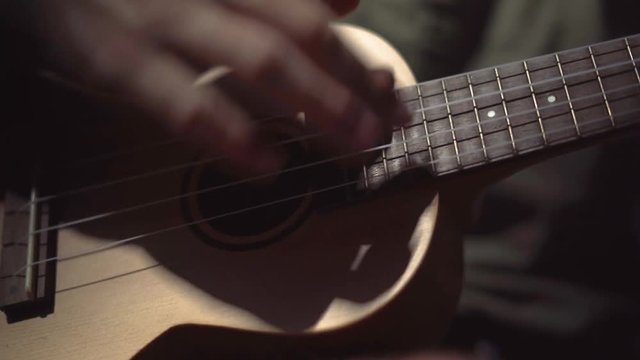 Close Up of a Man's Hands Strumming a Ukulele