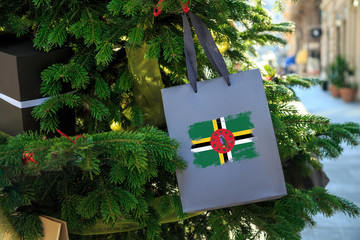 Dominica flag printed on a Christmas shopping bag. Close up of a shopping bag as a decoration on a...