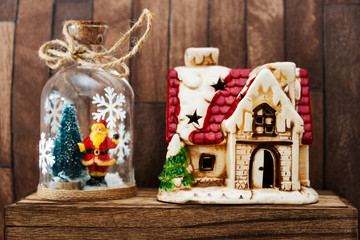Christmas trees and red house on vintage wooden background