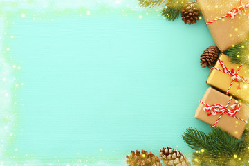 Christmas background with pine cones, fir branches and gifts over wooden white background. Flat lay, top view.