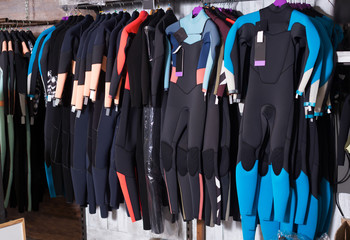 Image of colorful wetsuit hanging in the  store for surfing
