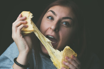 baked toast with stretched cheese in the hands of a woman