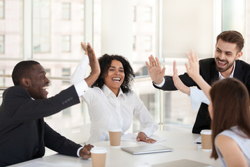 Excited diverse millennial workers give high five celebrate success, happy multiethnic colleagues...