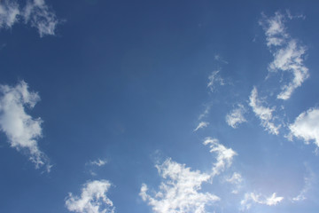 White puffy clouds deep blue sky sun formation composition moving fast