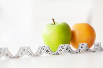 Diet. Fitness and healthy food diet concept. Balanced diet with vegetables. Fresh green vegetables, measuring tape on white background. Closeup