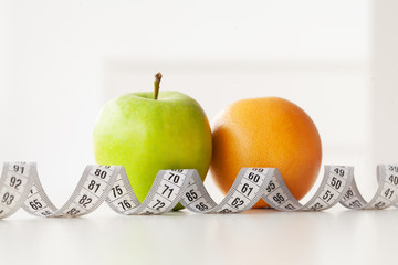 Diet. Fitness and healthy food diet concept. Balanced diet with vegetables. Fresh green vegetables, measuring tape on white background. Closeup