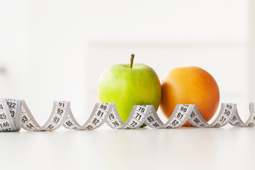 Diet. Fitness and healthy food diet concept. Balanced diet with vegetables. Fresh green vegetables, measuring tape on white background. Closeup