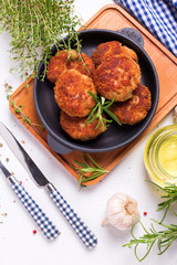 Homemade cutlets and herb and spices on frying pan  on wooden board
