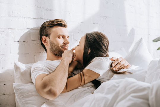 Happy Young Couple Relaxing In Bed Together