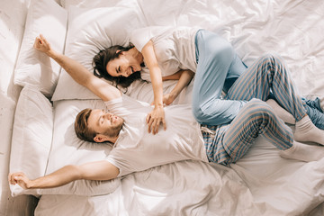 top view of happy young couple having fun in bed in morning