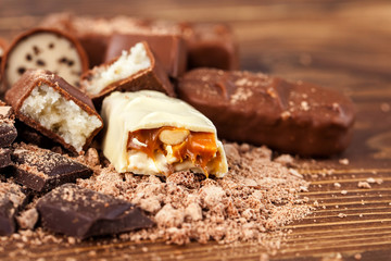 Various yummy chocolate candies on wooden table, sweets
