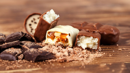 Various yummy chocolate candies on wooden table, sweets