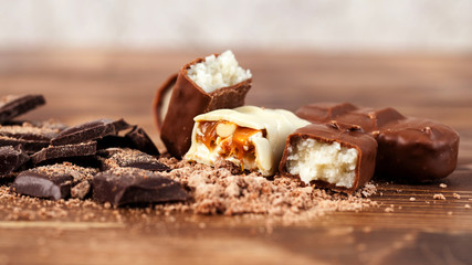 Various yummy chocolate candies on wooden table, sweets