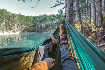 Woman relaxing in the hammock by the lake