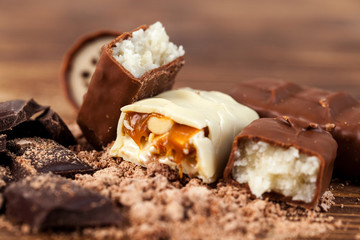Various yummy chocolate candies on wooden table, sweets