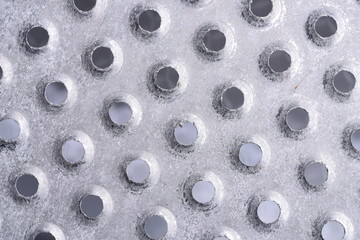 Metal background with circles holes closeup