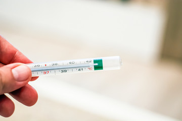 thermometer held by a male hand